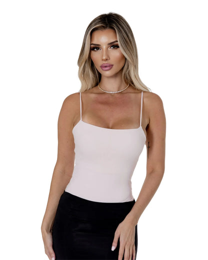 Model wearing the Elara Bodysuit in light pink, showcasing its sleek design and elegant fit.