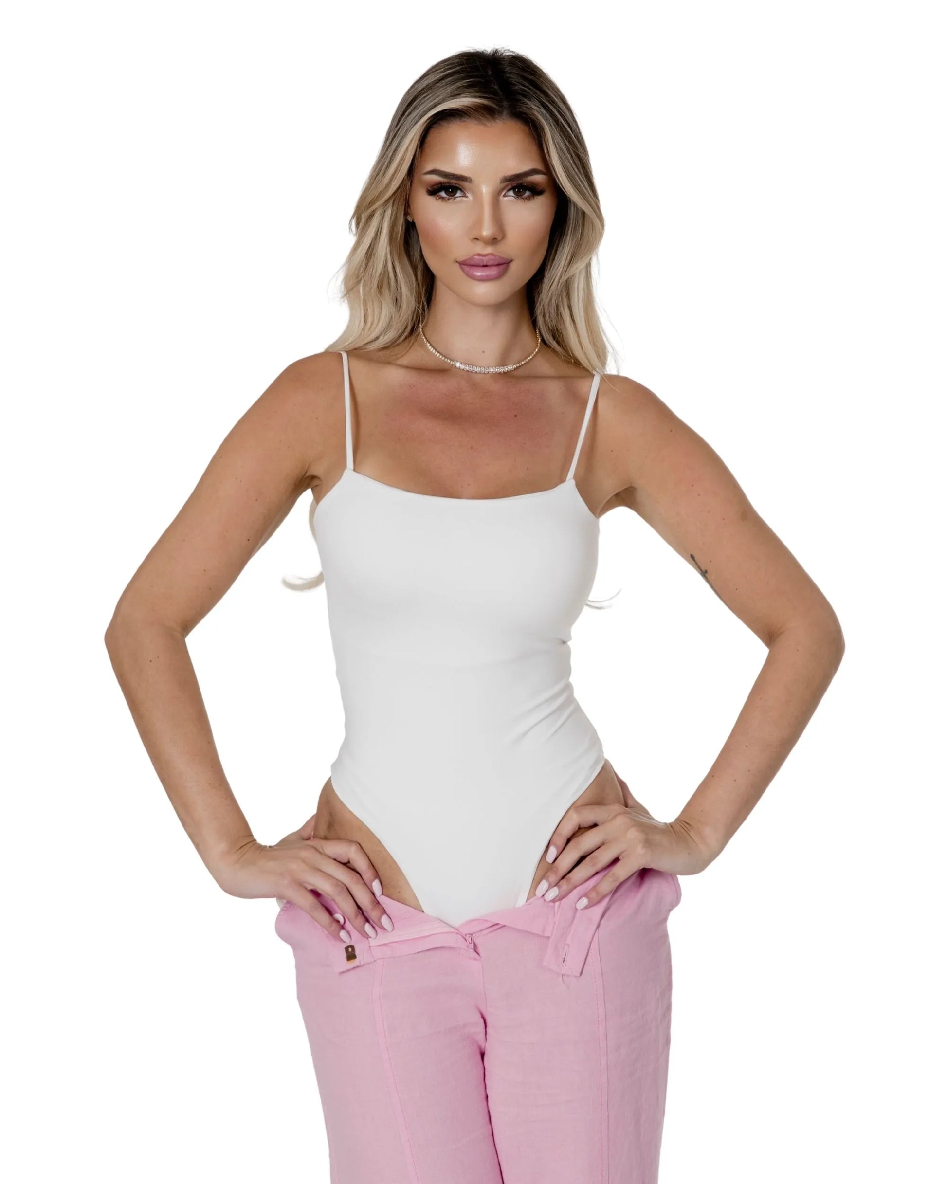 Model wearing the Elara Bodysuit with pink linen trousers, showcasing a stylish and modern look.